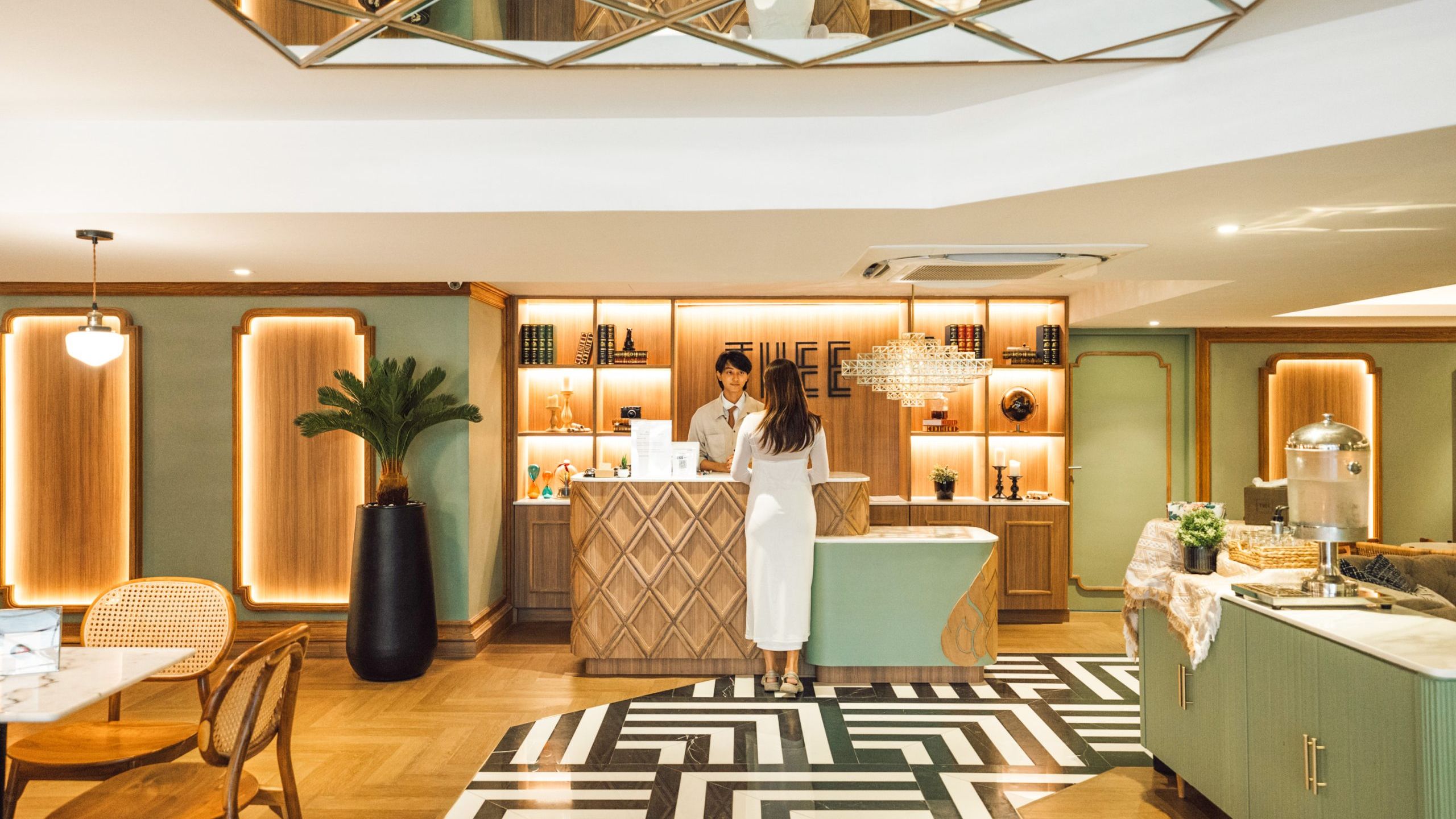 In the lobby area, there is a male receptionist welcoming guests at Bangkok Hotel Sukhumvit 20.